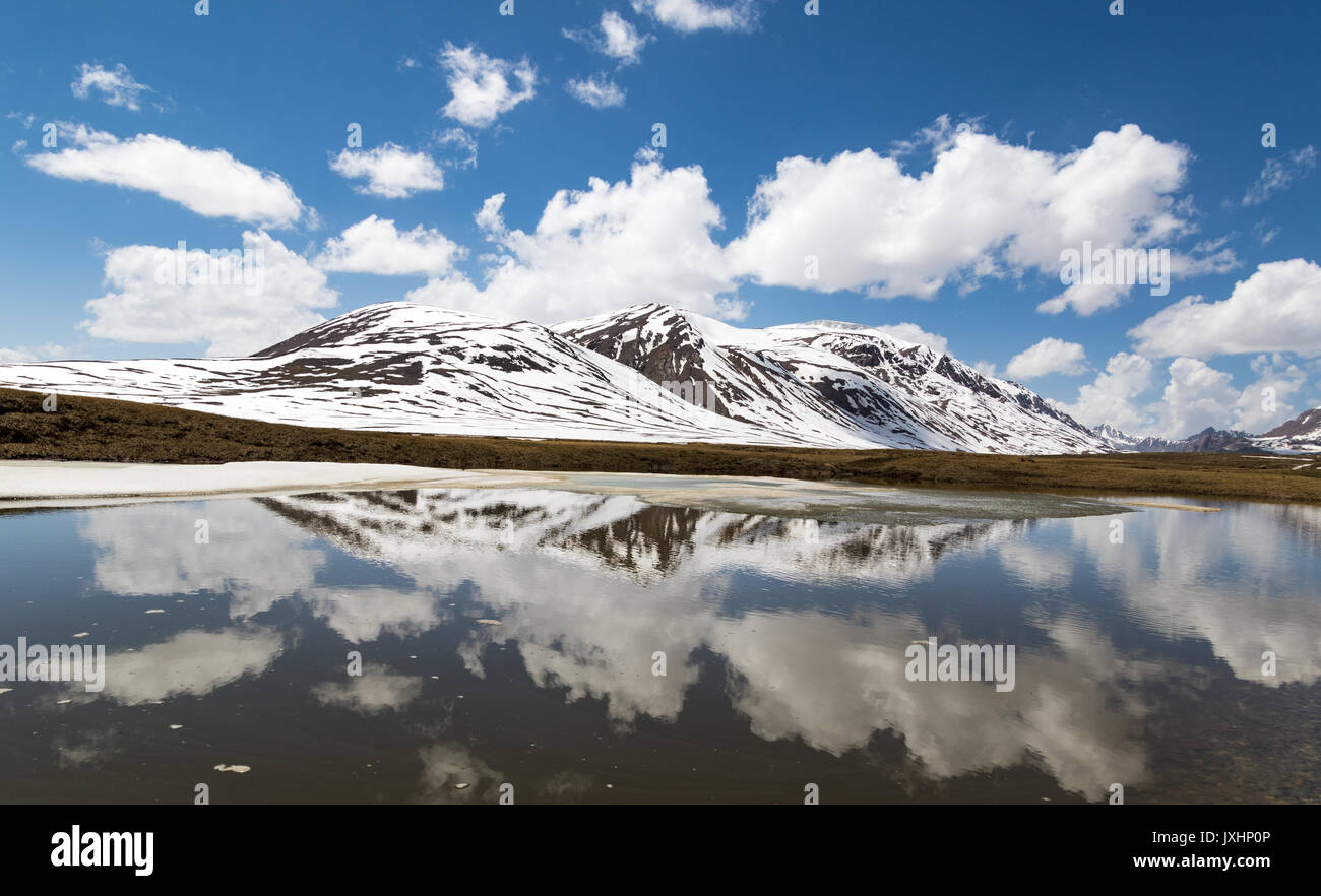 Alpine mountains and clouds reflected in lake Stock Photo - Alamy