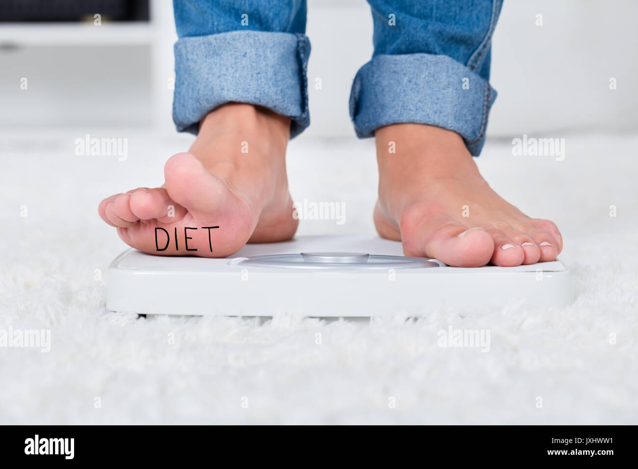 Woman standing on weight scales Stock Photo - Alamy