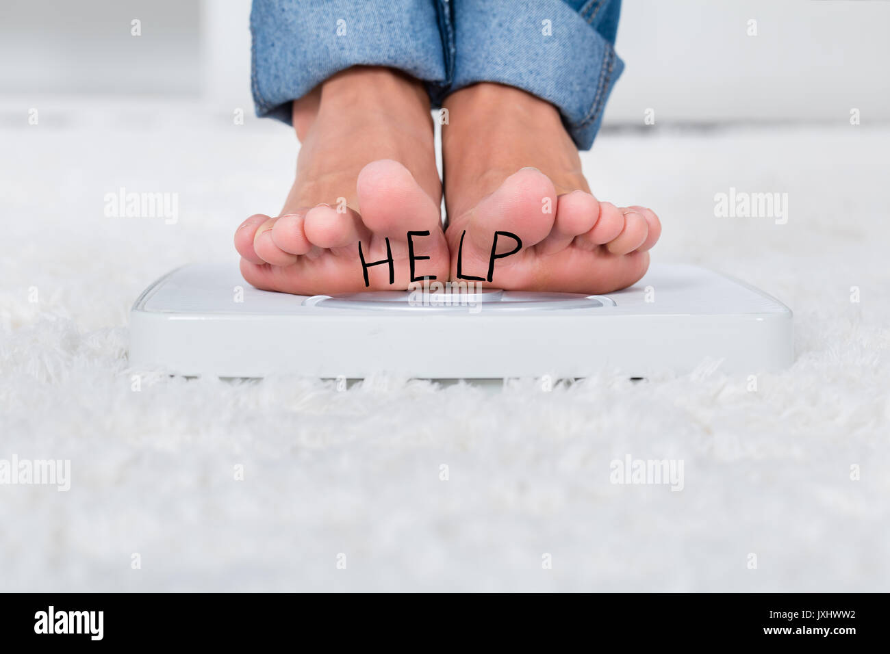 https://c8.alamy.com/comp/JXHWW2/close-up-of-person-feet-standing-on-weighing-scale-showing-help-text-JXHWW2.jpg