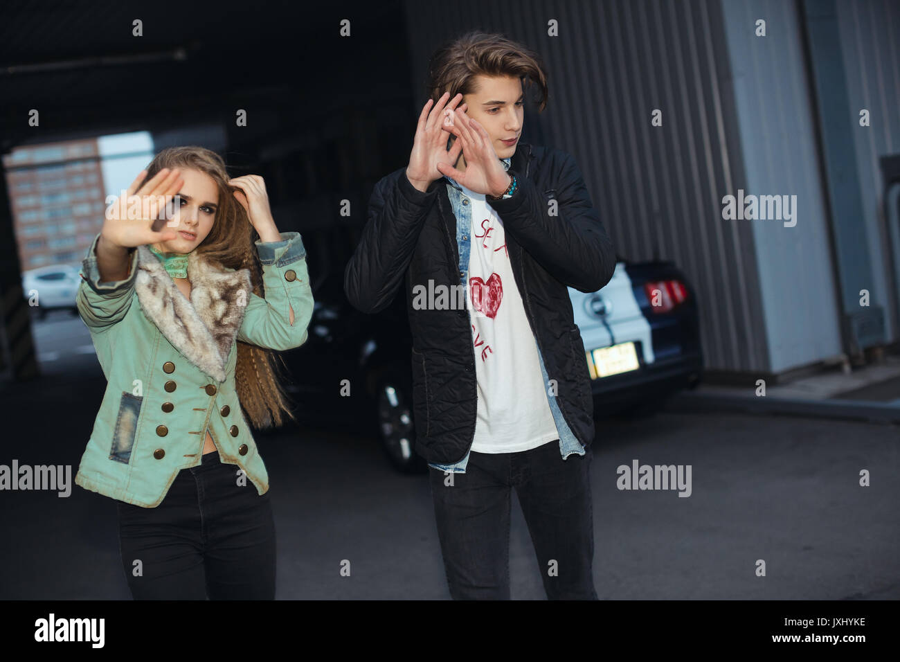 Couple hiding faces from paparazzi outdoors Stock Photo