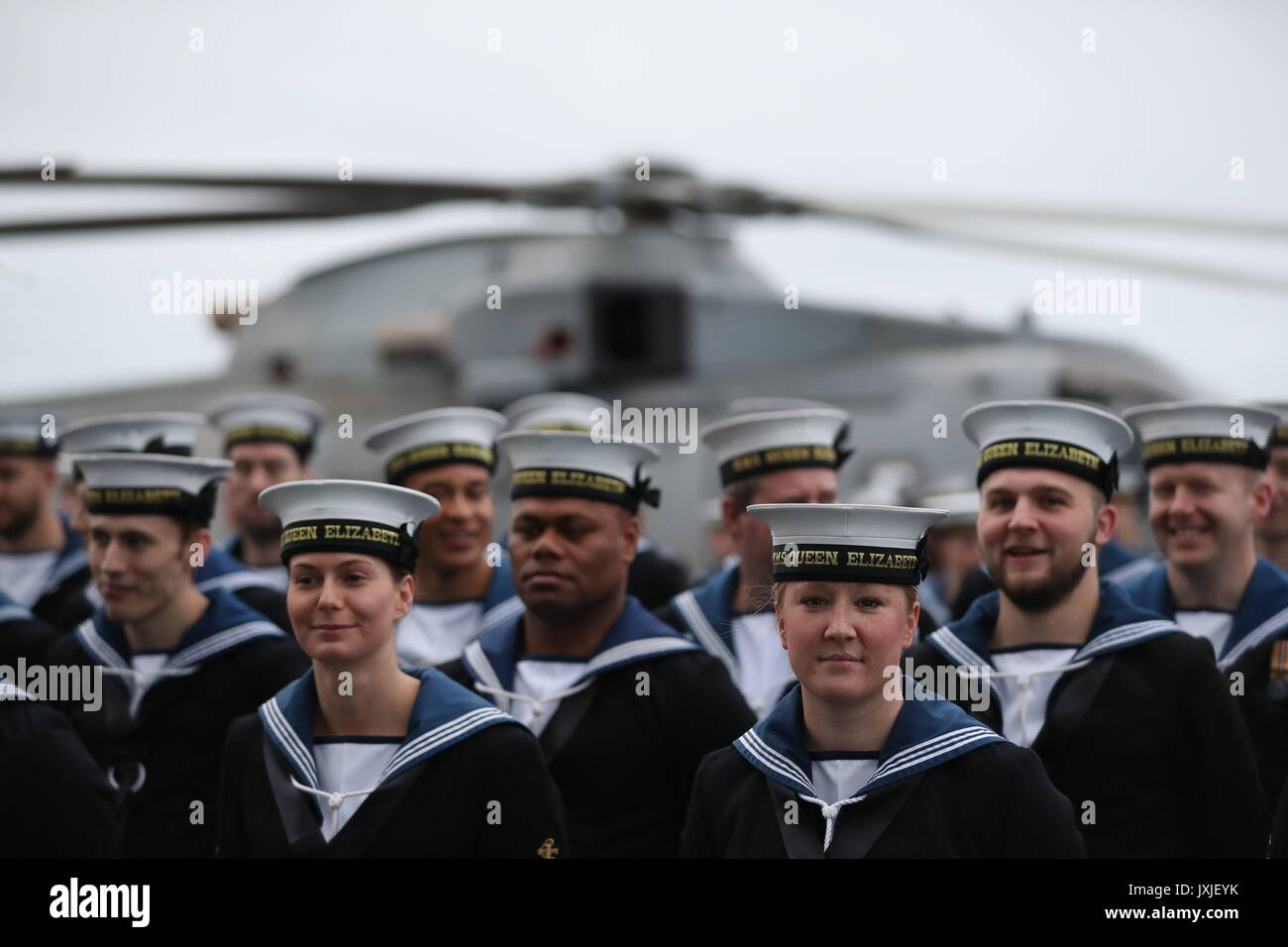 Members of the crew of HMS Queen Elizabeth, the UK's newest aircraft carrier, muster on the deck ahead of the ship's arrival in Portsmouth. Stock Photo