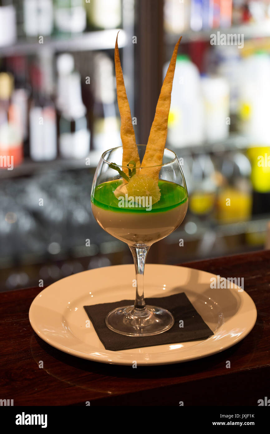 Elegant dessert in wine glass with bar fridge in background Stock Photo