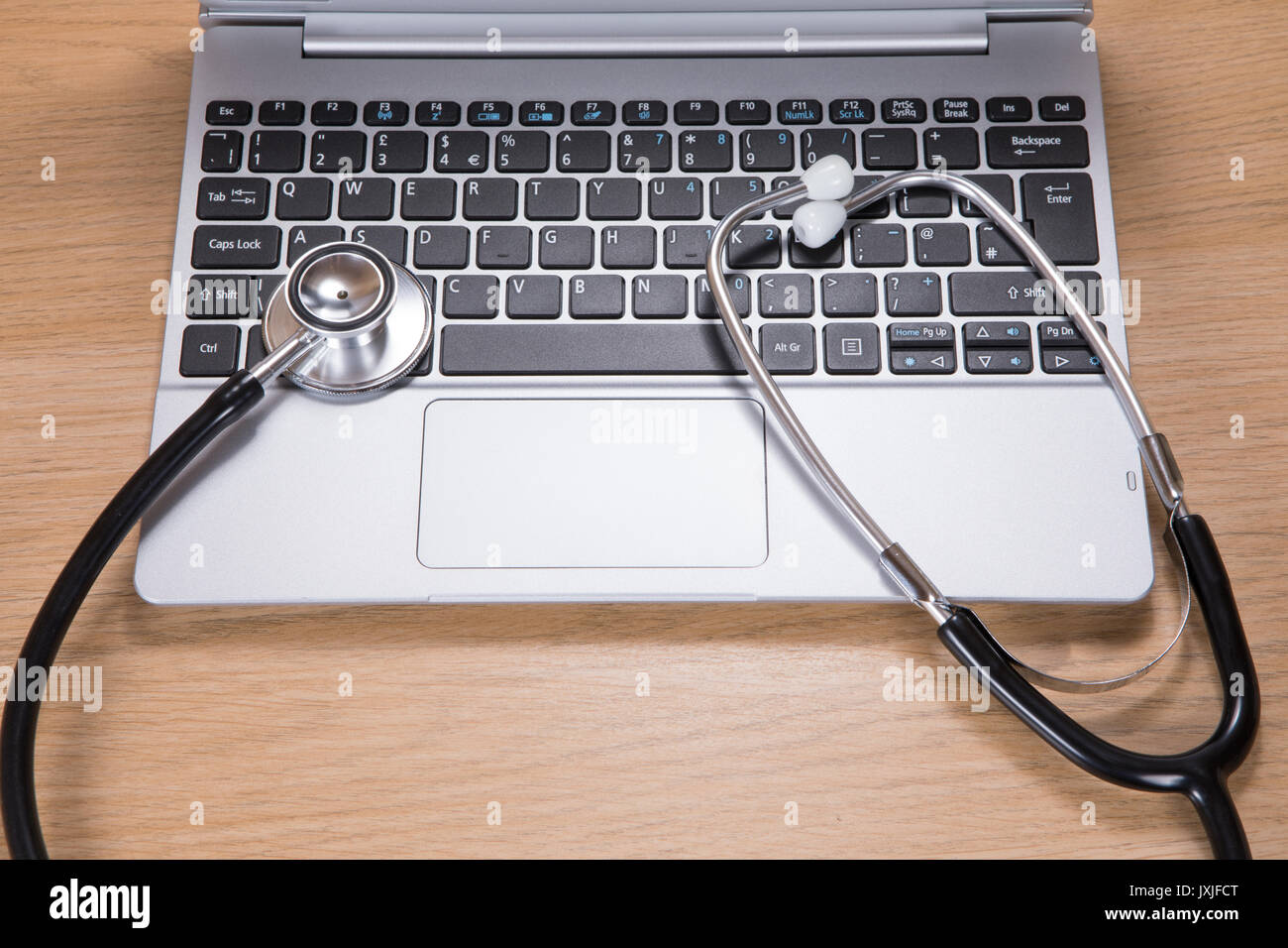 Overhead view of black and silver medical stethoscope on laptop ...