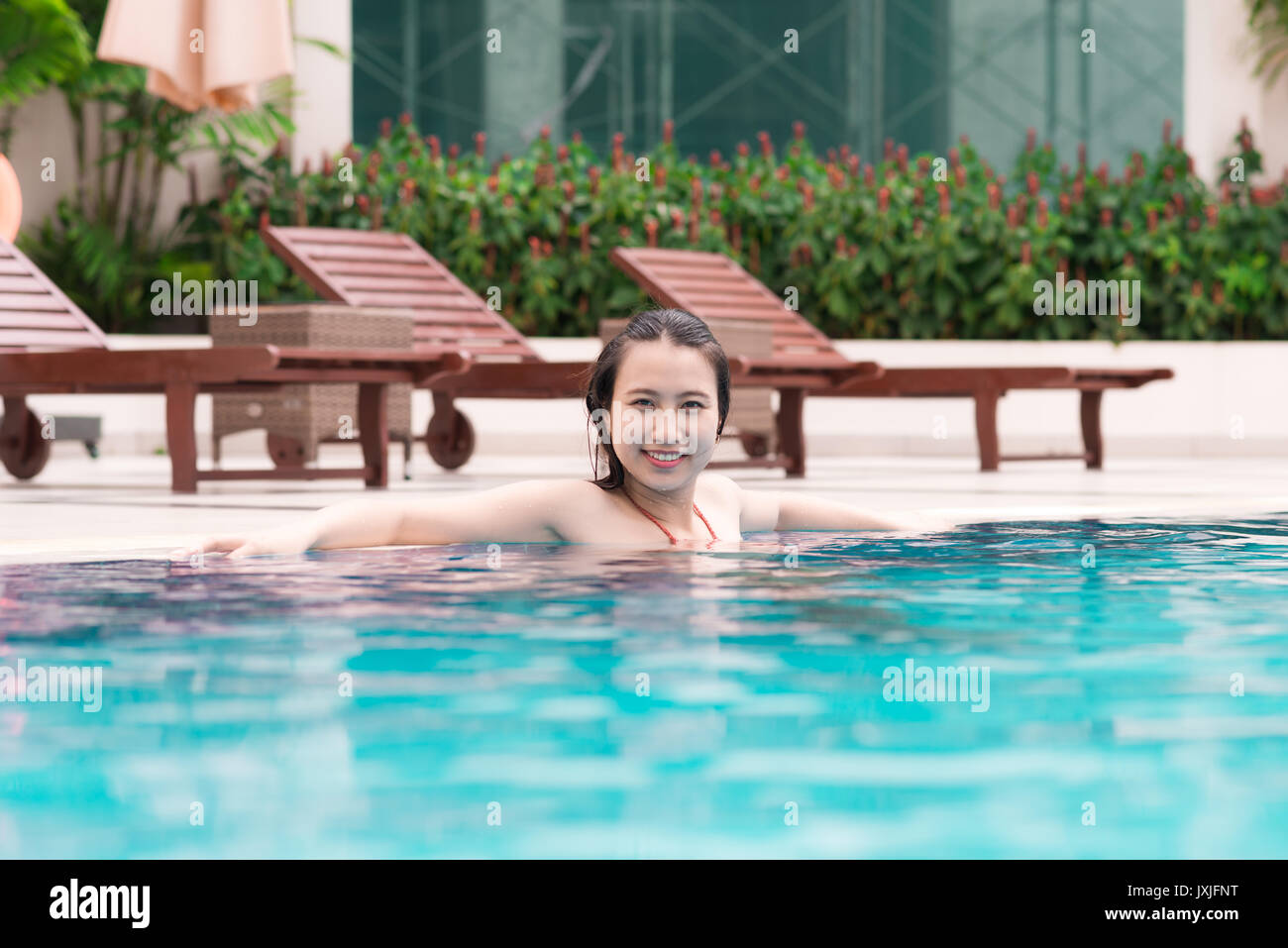 Beautiful asian woman smiling in a swimming pool Stock Photo - Alamy