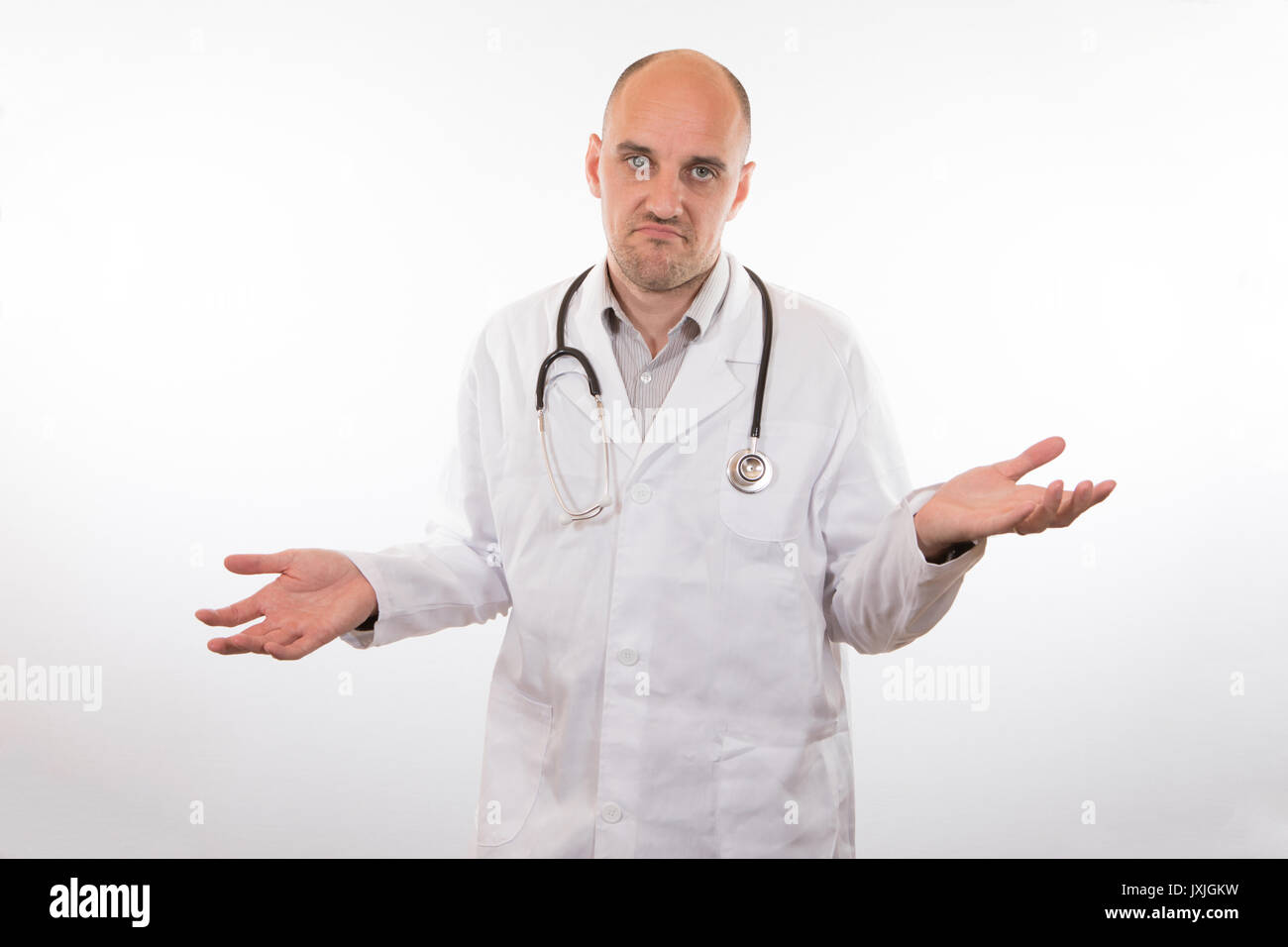 Resigned unhappy doctor shrugging his shoulders to show his ignorance or  inability to help a patient Stock Photo - Alamy