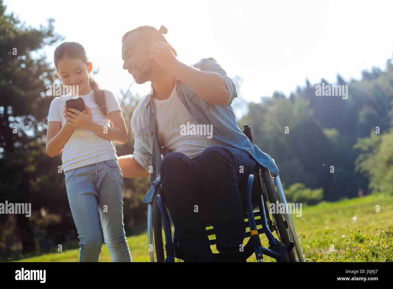 Daughter and her disabled father listening to music together Stock Photo