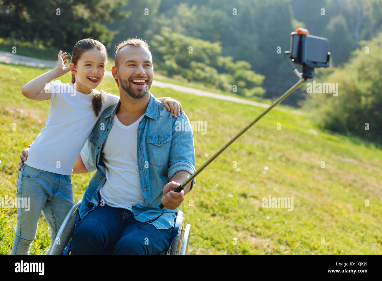 Father in a wheelchair and daughter posing for a selfie Stock Photo - Alamy