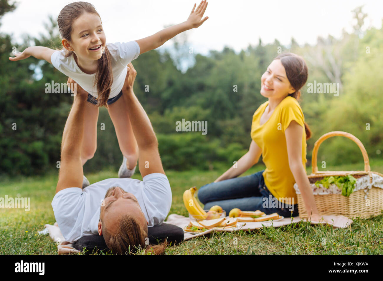 Adorable girl being lifted up by her loving father Stock Photo