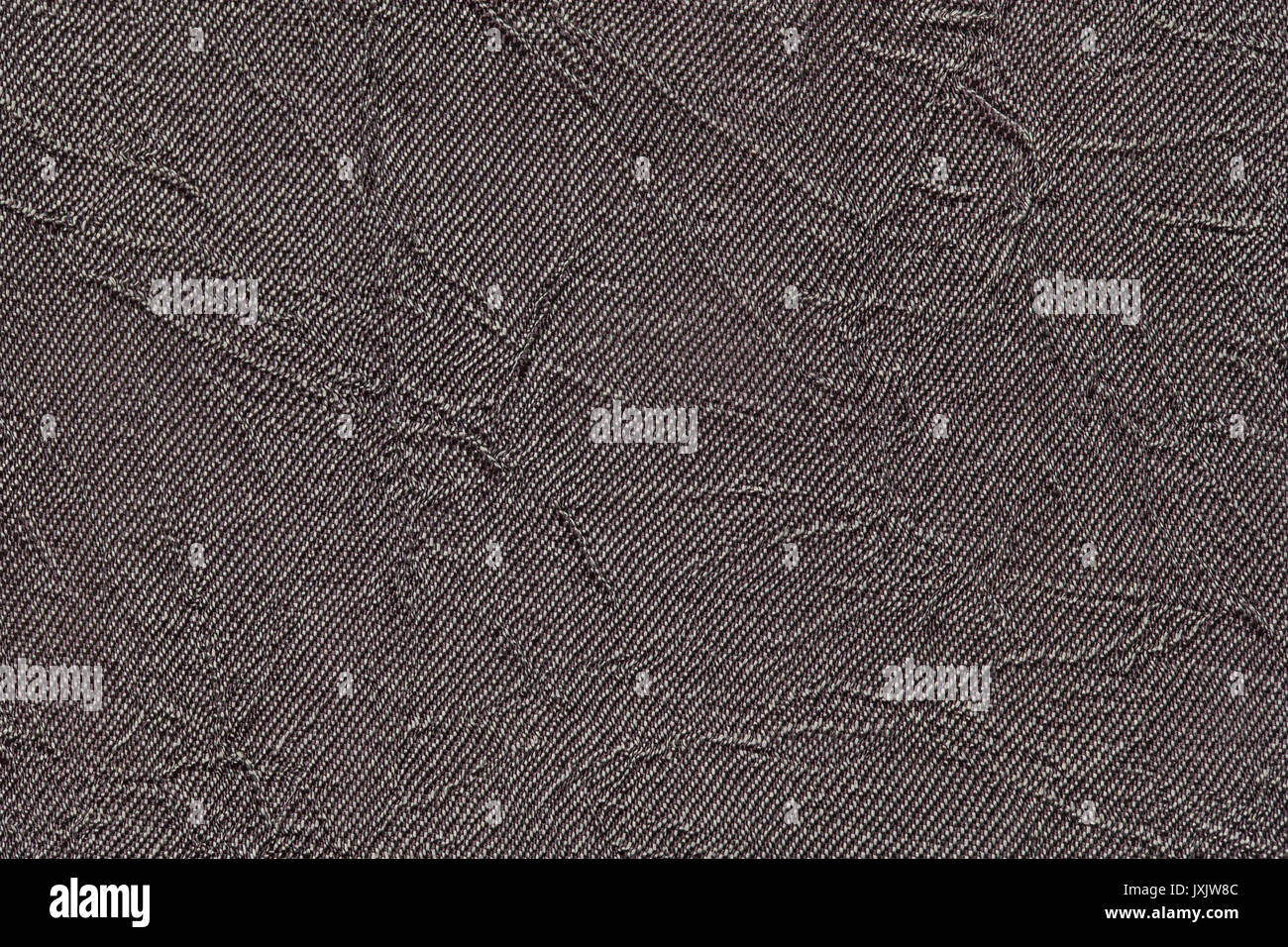 Dark gray wavy background from a textile material. Fabric with fold texture closeup. Creased shiny brown cloth. Stock Photo