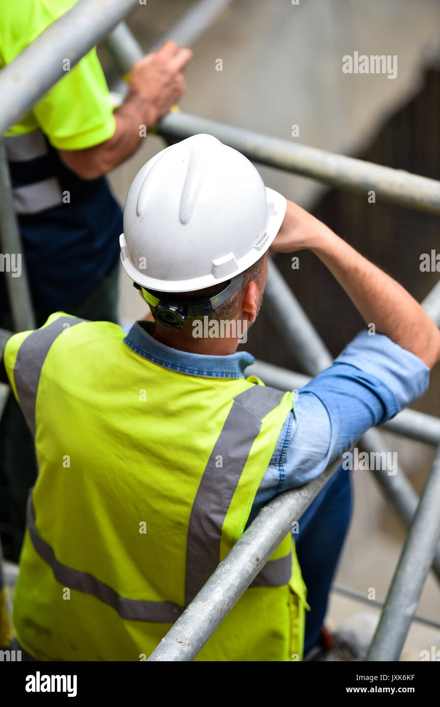 Workers inspecting construction works on a scaffold inside construction ...