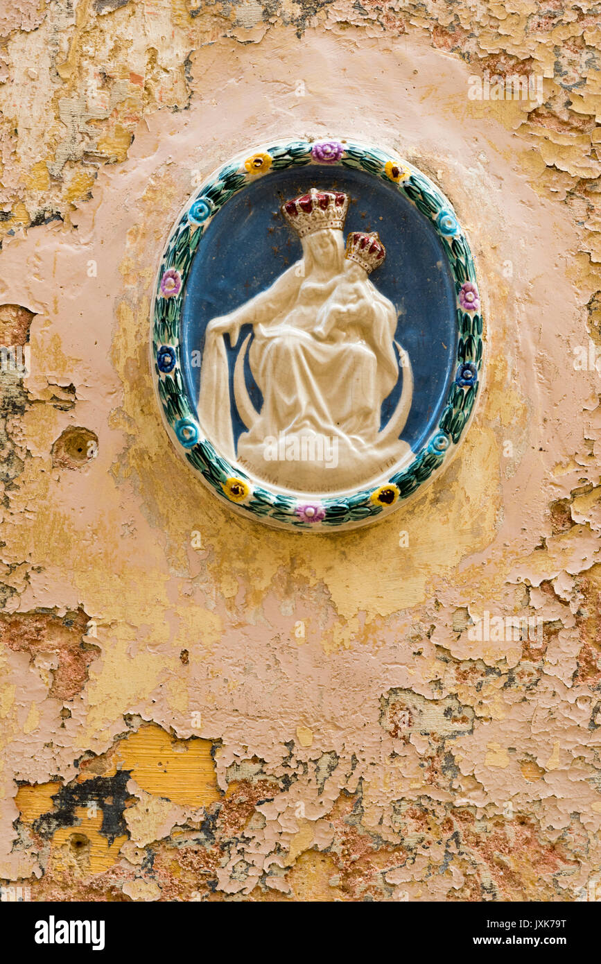 A ceramic Madonna religious decoration on an old wall with peeling paint in Mdina Malta Stock Photo
