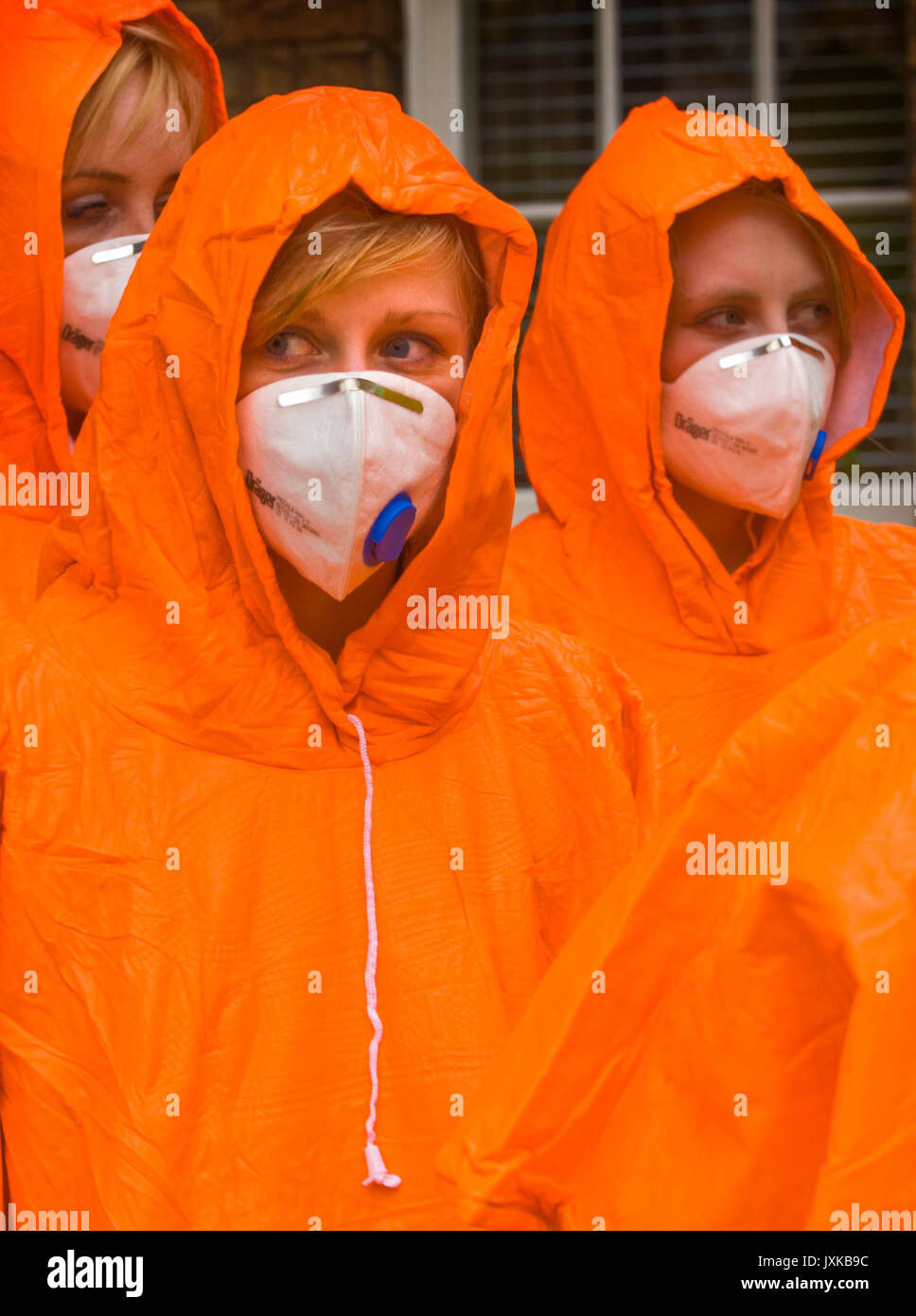 Medical students taking part in a simulated chemical contamination emergency wear brightly coloured coveralls and leave their own clothing in the desi Stock Photo