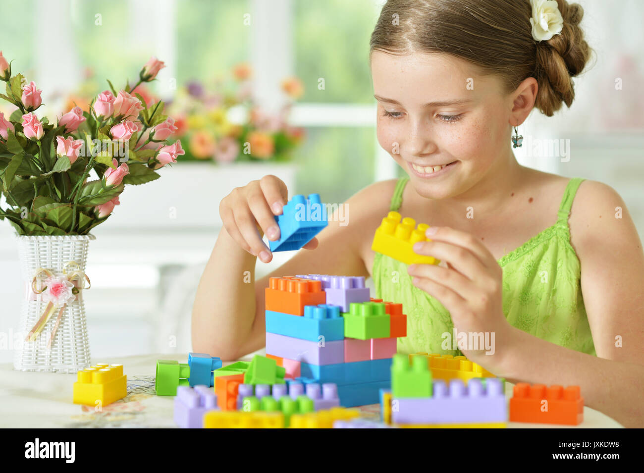 Cute girl playing with plastic blocks Stock Photo - Alamy