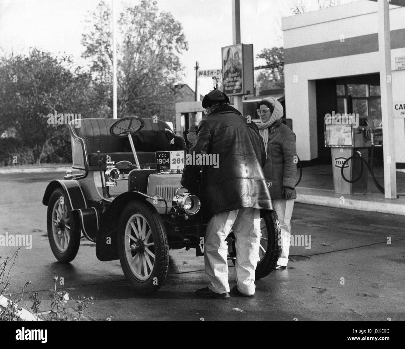 A vintage car stops at a petrol station at  Horley in Surrey, England during the annual London-Brighton Veteran Car Run on November 6, 1977. Often known as the Old Crocks Race, the run is one of the longest running motoring events in the World. Stock Photo