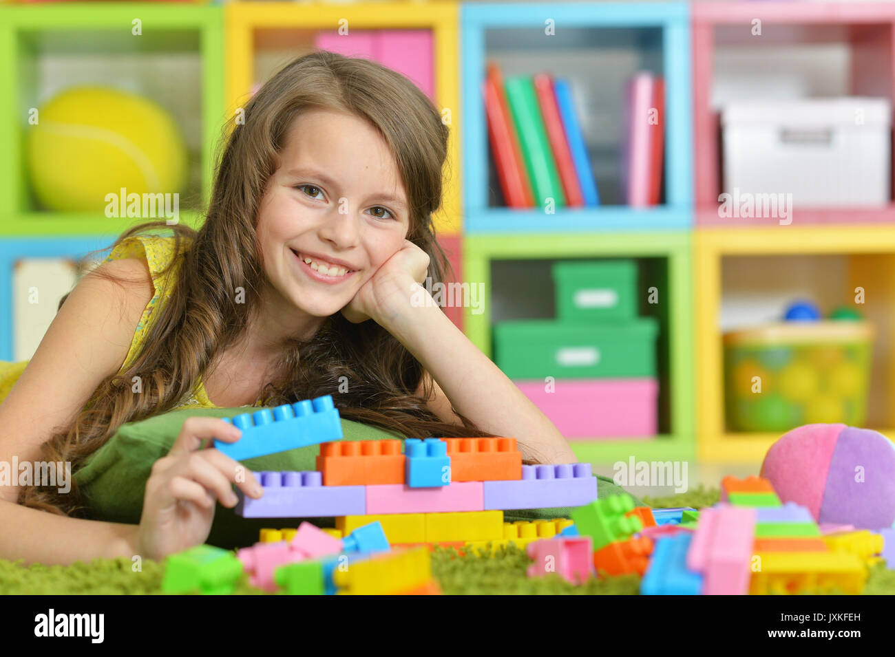 Cute girl playing with colorful plastic blocks Stock Photo - Alamy