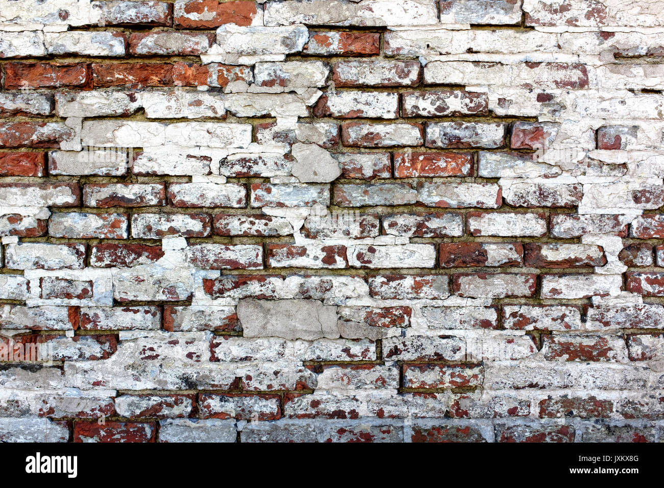 Rough ed brick wall, straight on with white plaster crumbling Stock Photo