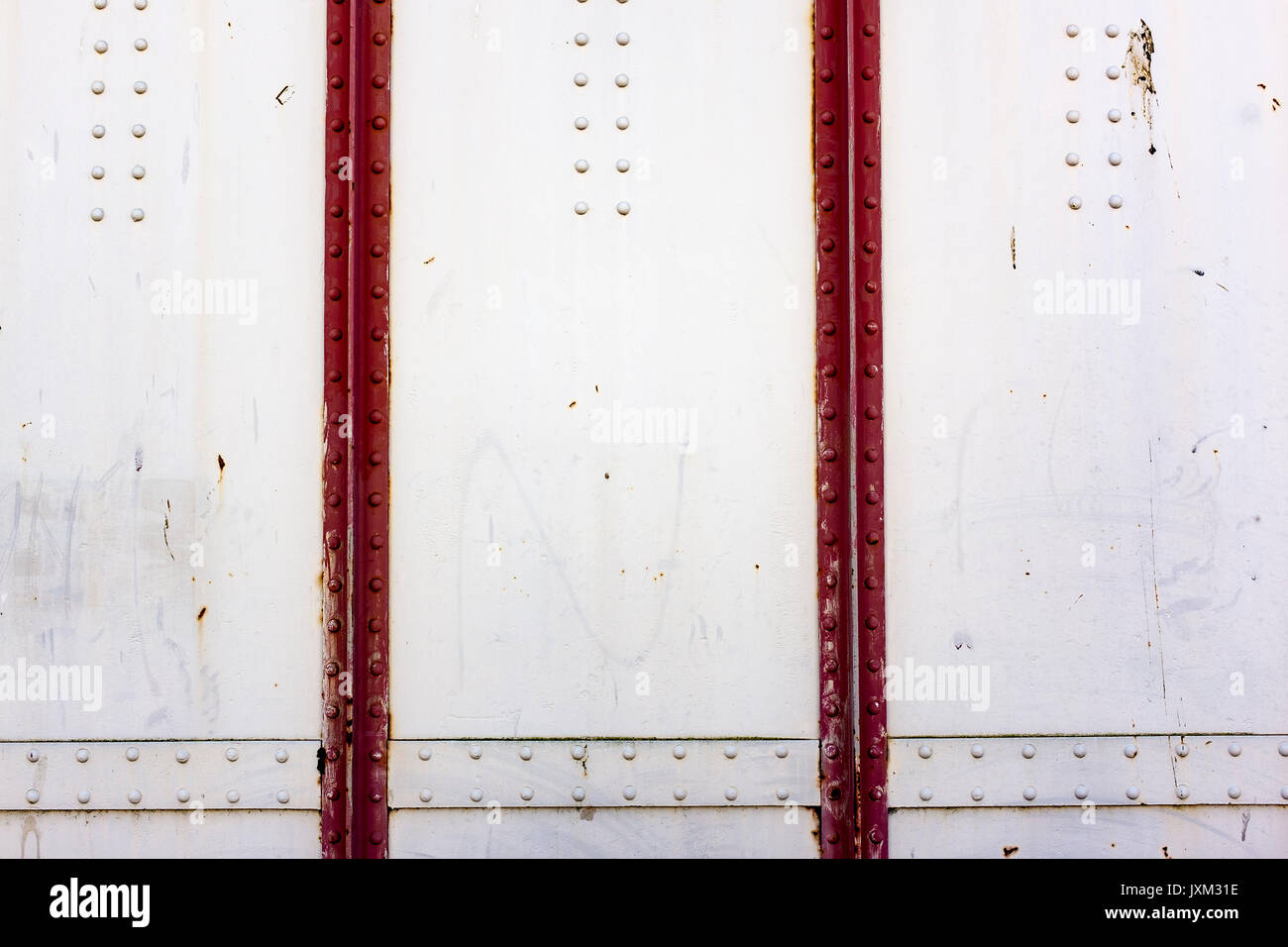 Detail shot of a red and white cast iron wall, with rivets Stock Photo