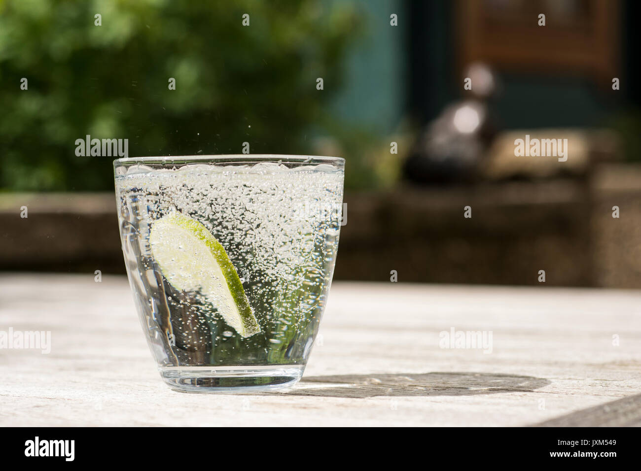 Glass of gin and tonic or vodka and tonic or fizzy water on a wooden