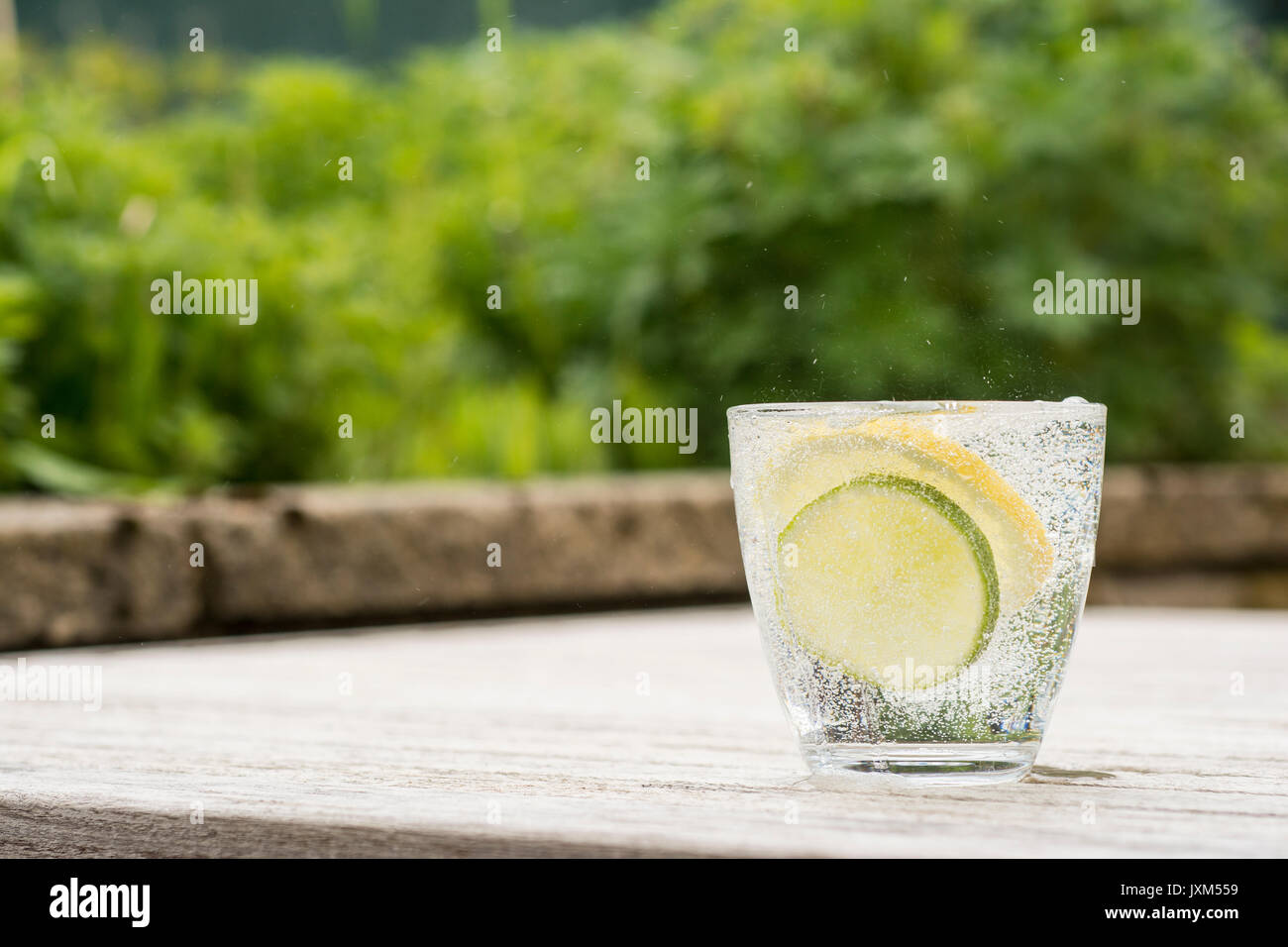 Glass of gin and tonic or vodka and tonic or fizzy water on a wooden