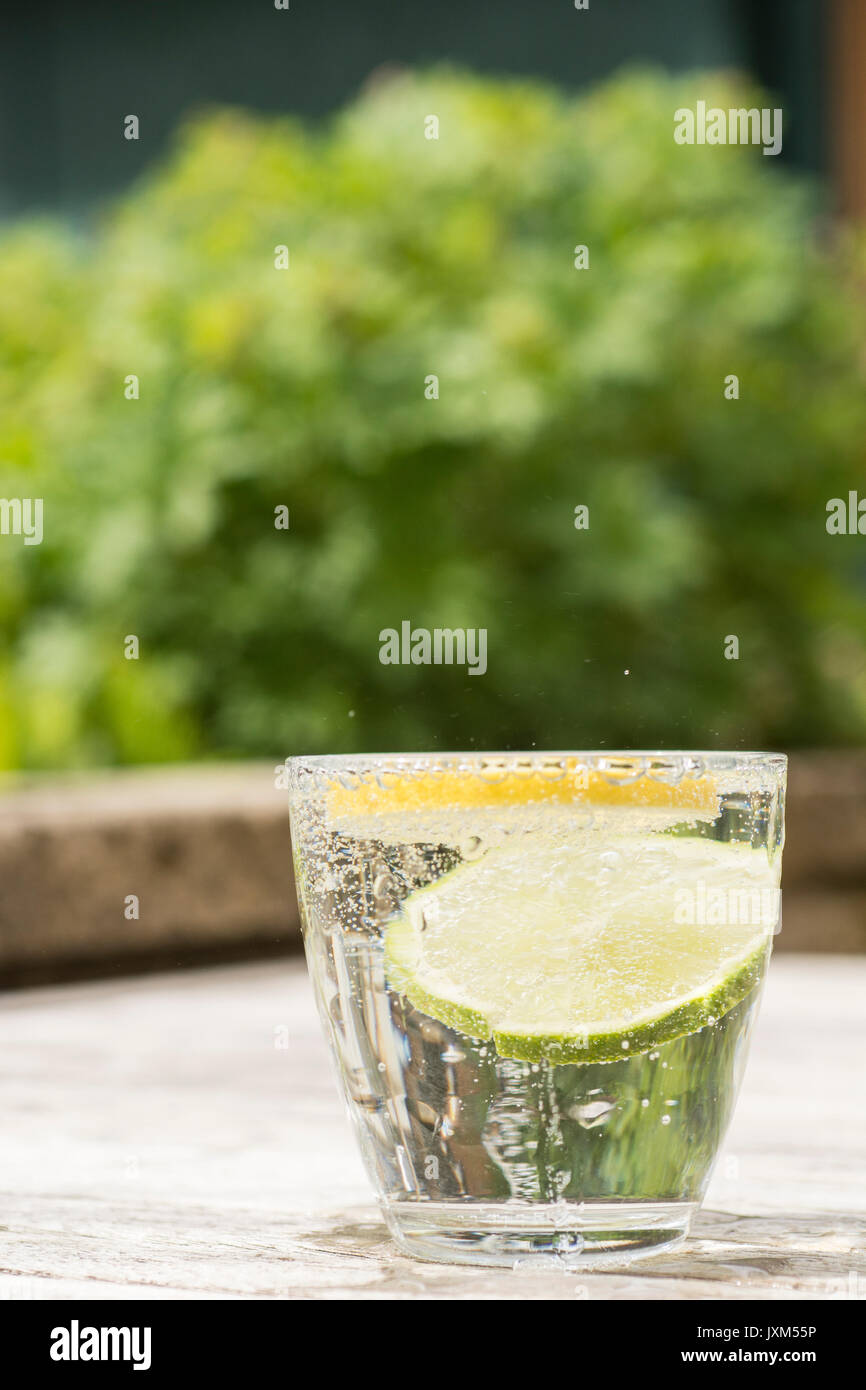 Glass of gin and tonic or vodka and tonic or fizzy water on a wooden