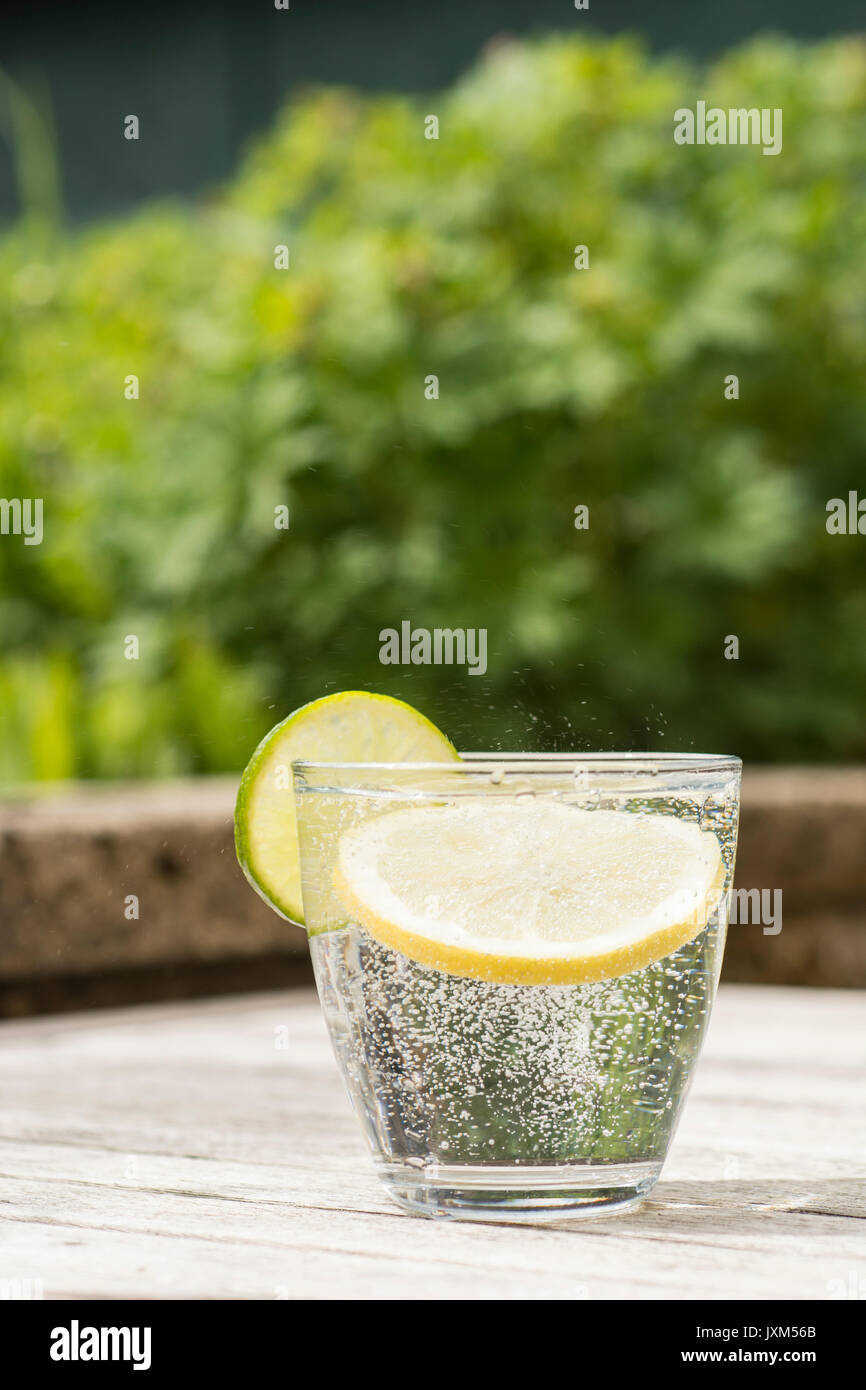 Glass of gin and tonic or vodka and tonic or fizzy water on a wooden
