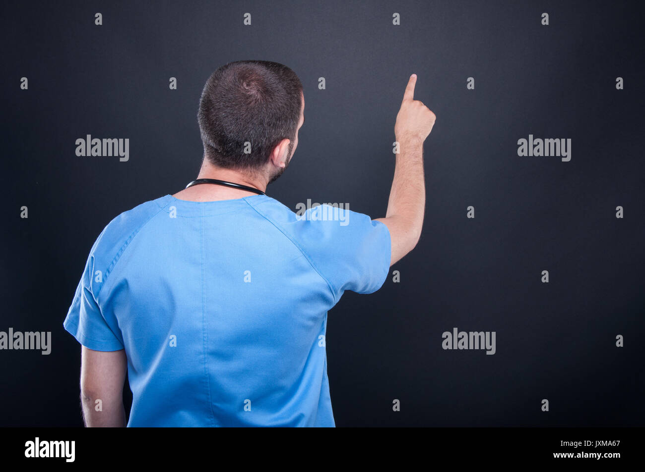 Back view of doctor with stethoscope using invisible touchscreen on black background with copy text space Stock Photo