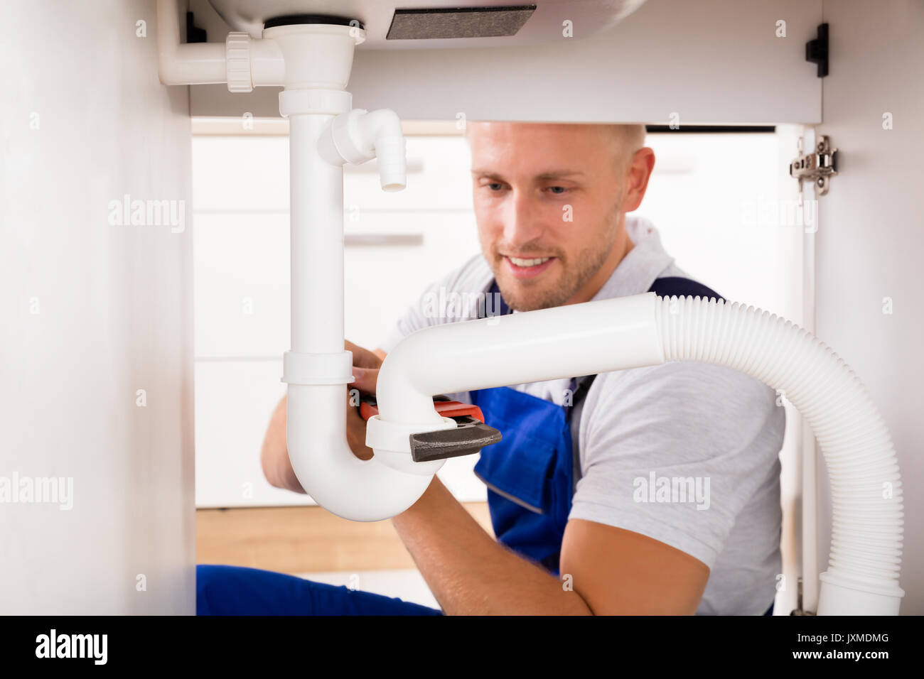 Plumber Tightening Sink Pipe With Adjustable Wrench Stock Photo Alamy