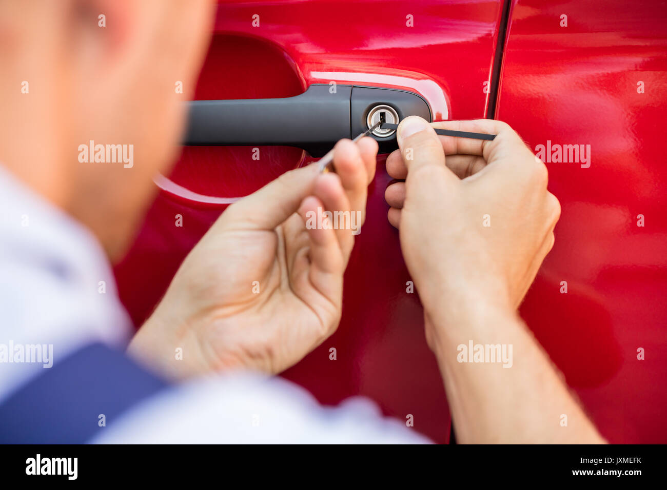 Close-up Of Person's Hand Opening Car Door With Lockpicker Stock Photo