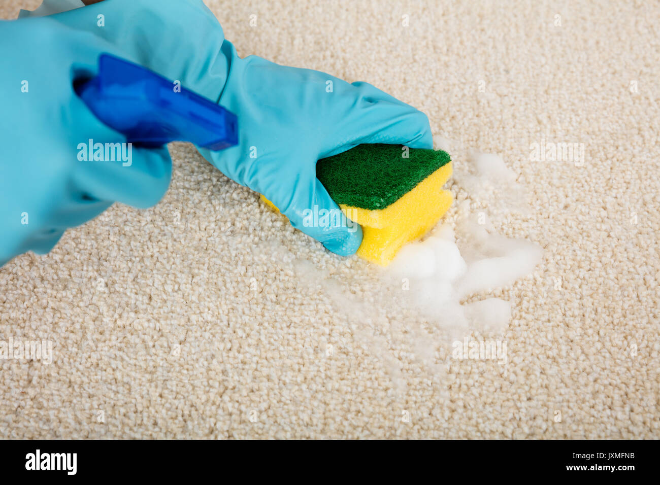 Close-up Of Person's Hand Cleaning Carpet With Sponge Stock Photo