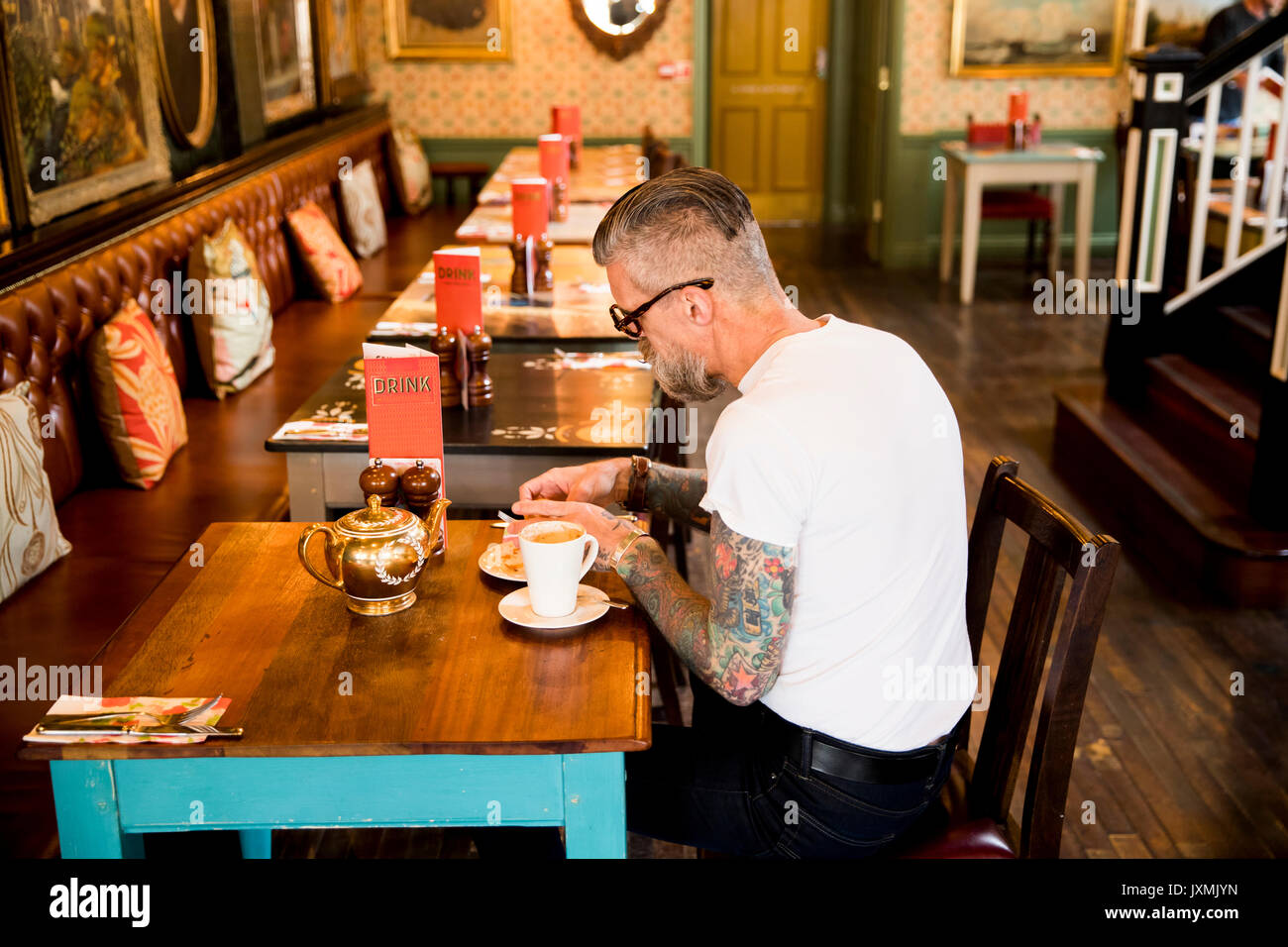 Quirky man eating in bar and restaurant, Bournemouth, England Stock Photo