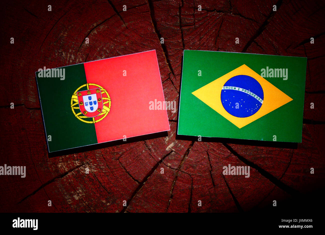 Portuguese flag with Brazilian flag on a tree stump isolated Stock Photo Alamy