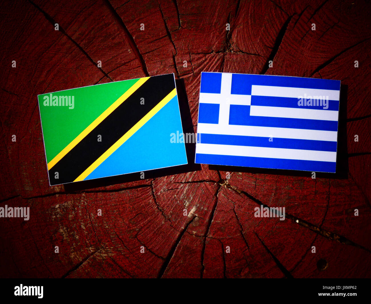 Tanzanian Flag With Greek Flag On A Tree Stump Isolated Stock Photo Alamy