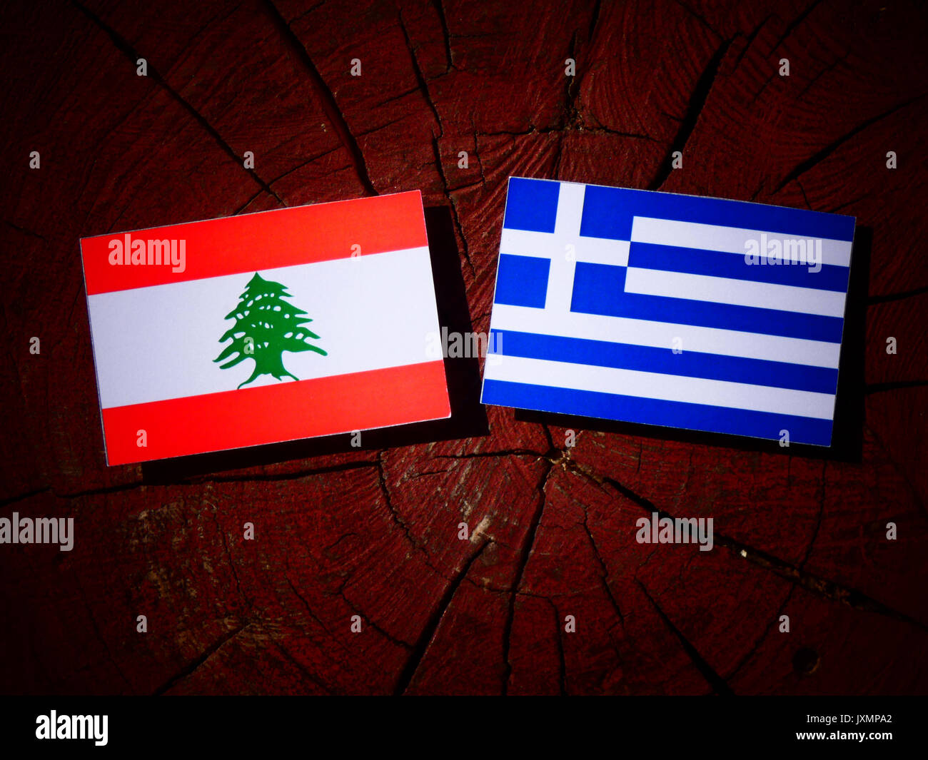 Lebanese flag with Greek flag on a tree stump isolated Stock Photo