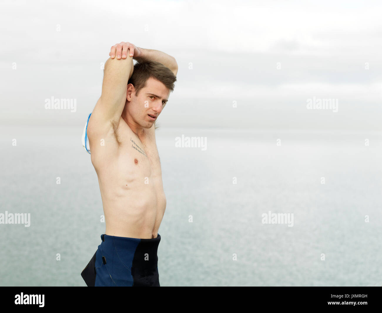 Bare chested man warming up, stretching arms, Melbourne, Victoria, Australia, Oceania Stock Photo