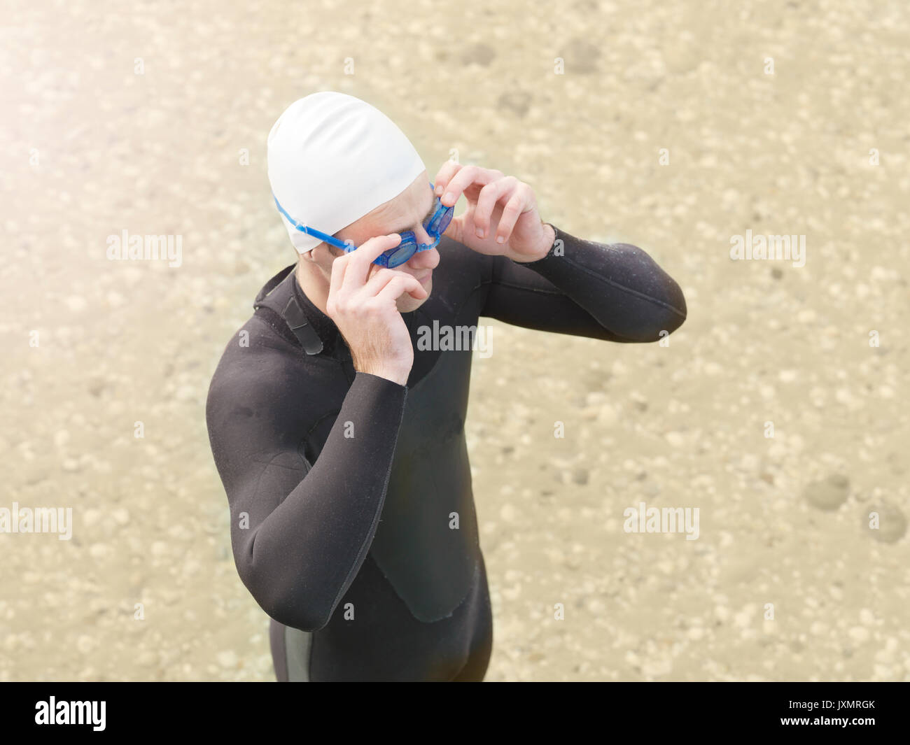 Man on beach wearing wetsuit, swimming cap and goggles, Melbourne, Victoria, Australia, Oceania Stock Photo