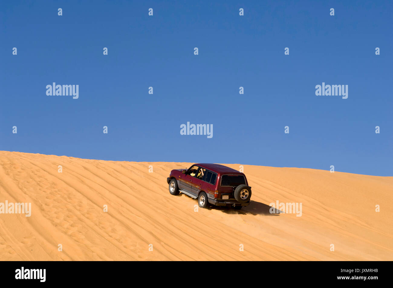 SUV on sand dunes, Erg Awbari, Sahara desert, Fezzan, Libya Stock Photo