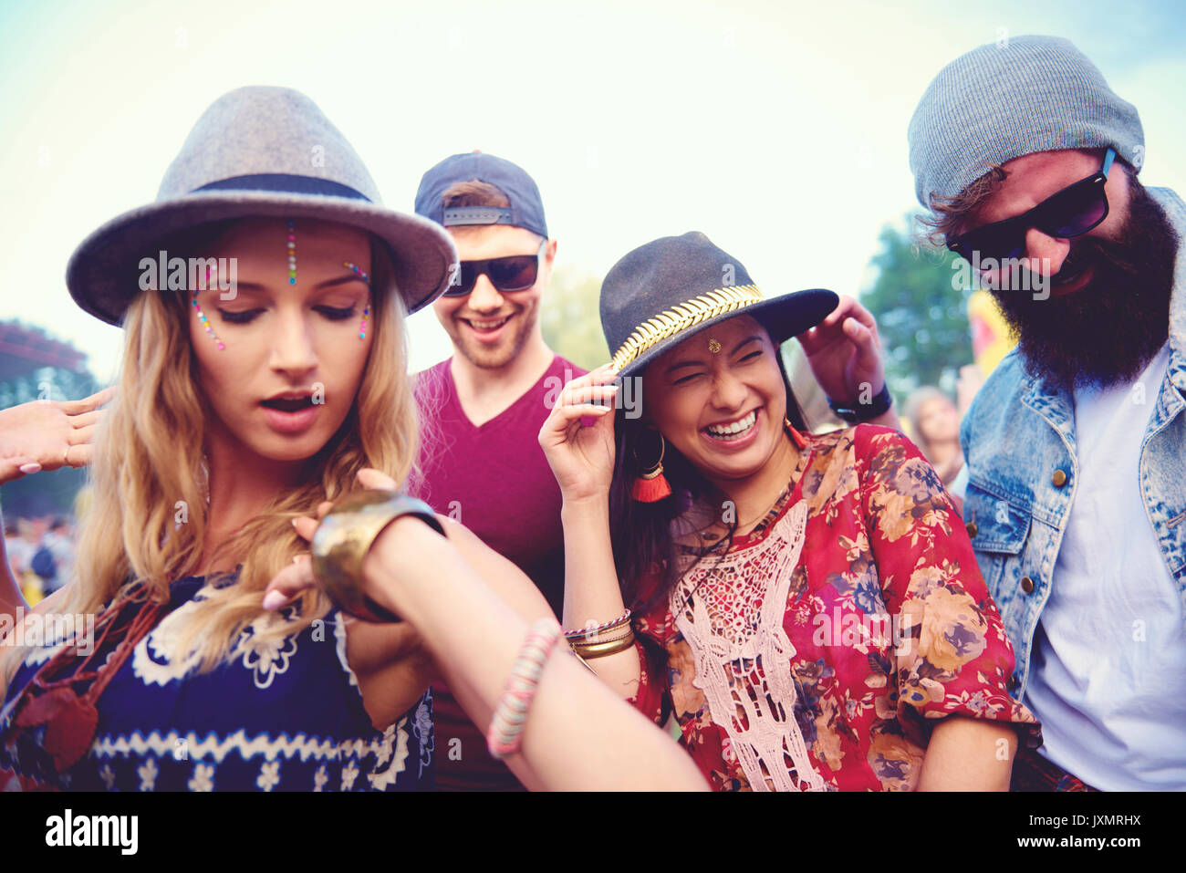 Four young adult friends in fedoras dancing at festival Stock Photo