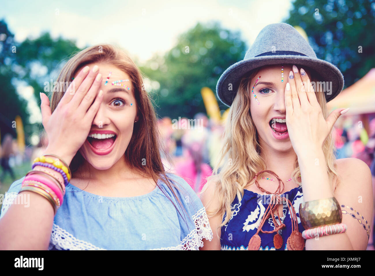 Portrait of two young female friends covering an eye at festival Stock Photo