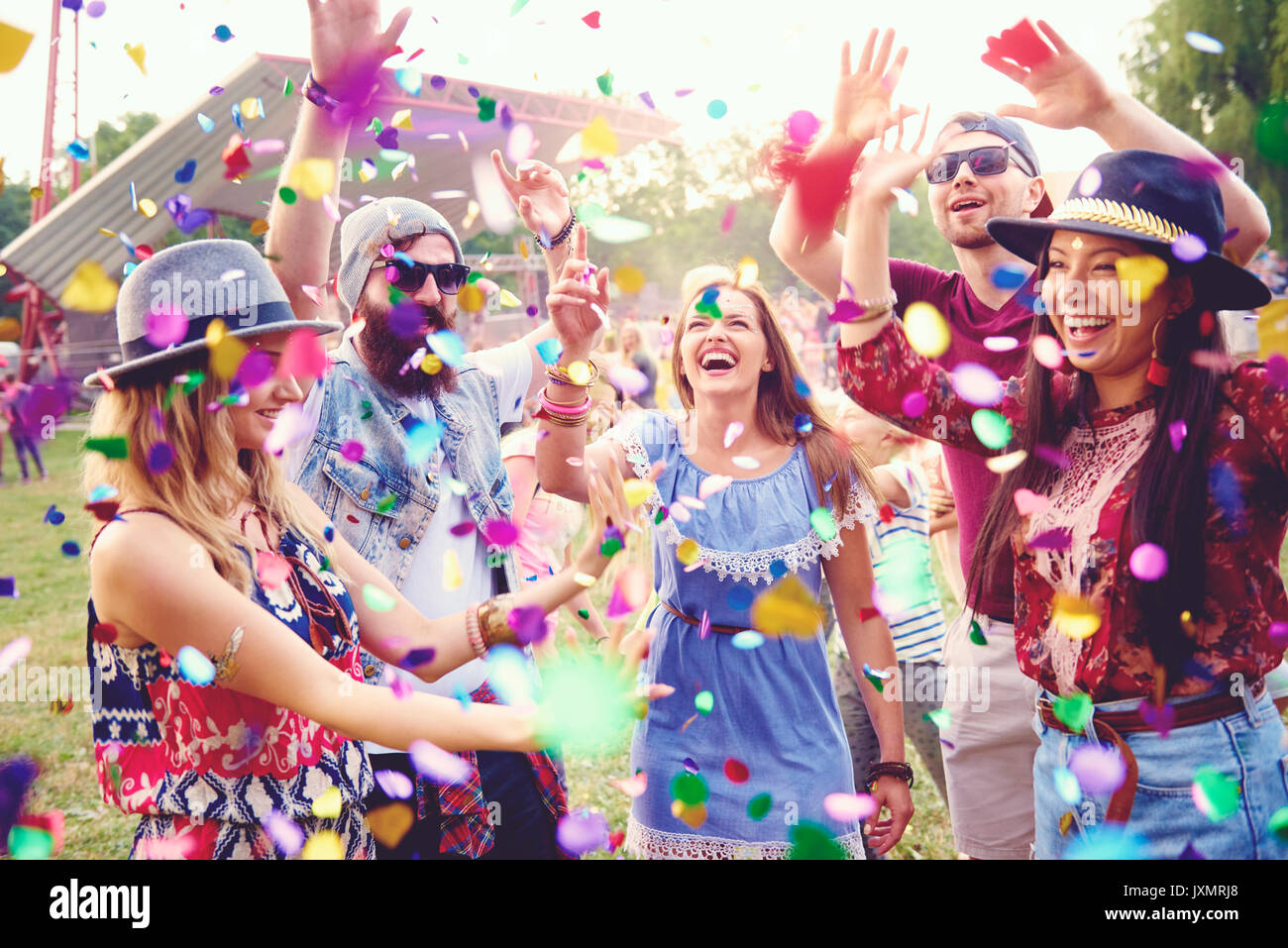 Young adult friends throwing confetti at festival Stock Photo