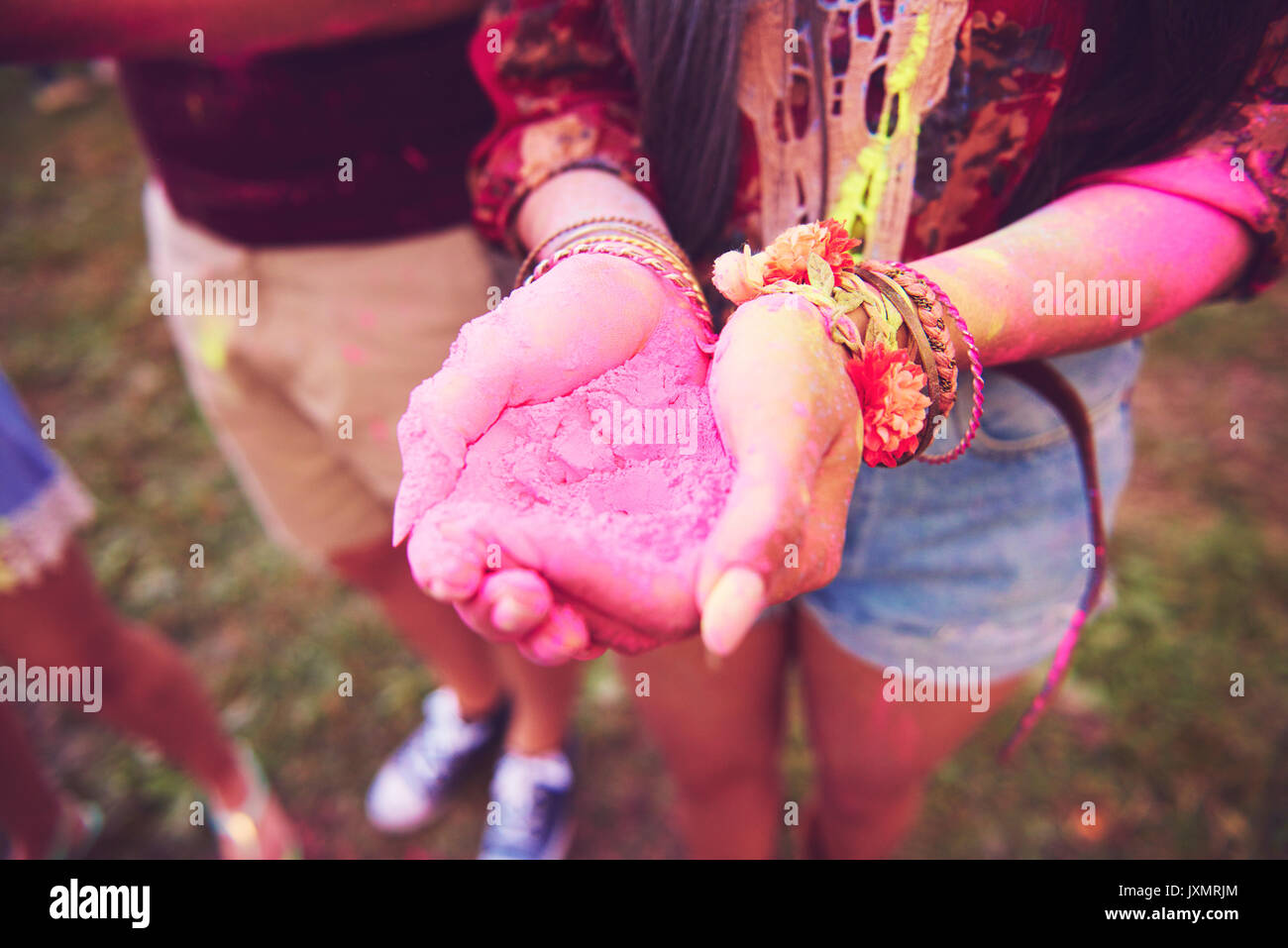 Pink chalk cupped in young woman's hands at festival Stock Photo