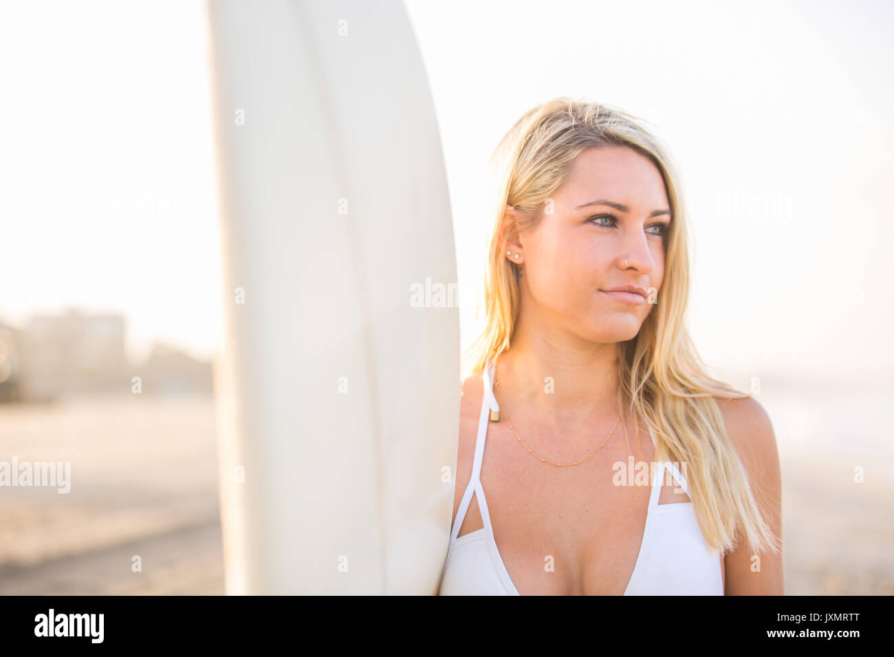 Young female surfer in bikini top gazing from beach, Santa Monica, California, USA Stock Photo