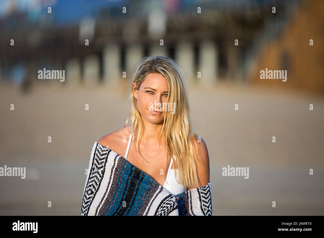 Portrait of sultry young woman wrapped in blanket on beach, Santa Monica, California, USA Stock Photo
