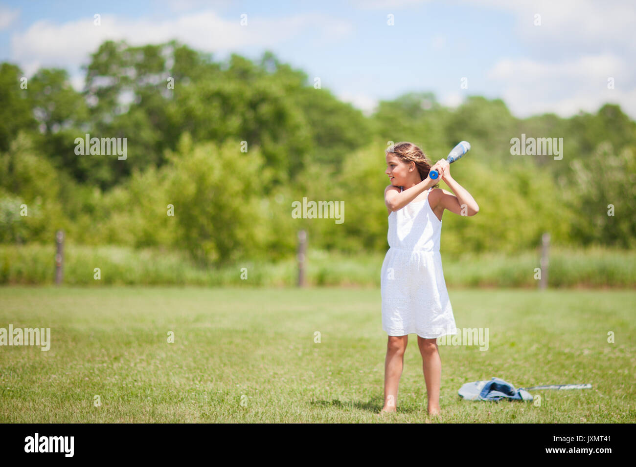 Girl playing baseball on field Stock Photo
