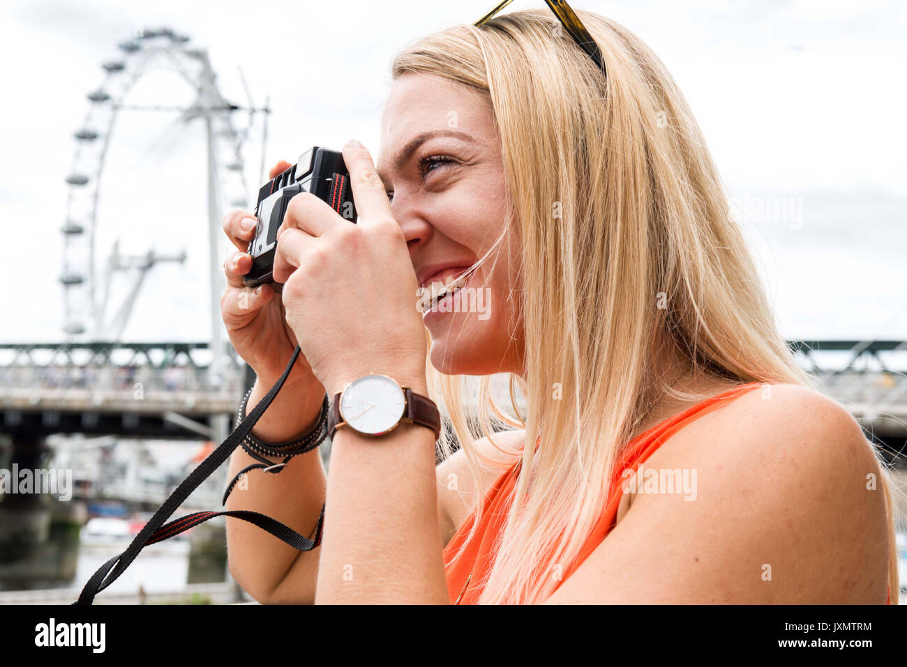 Female tourist in London, photographing view, using camera Stock Photo