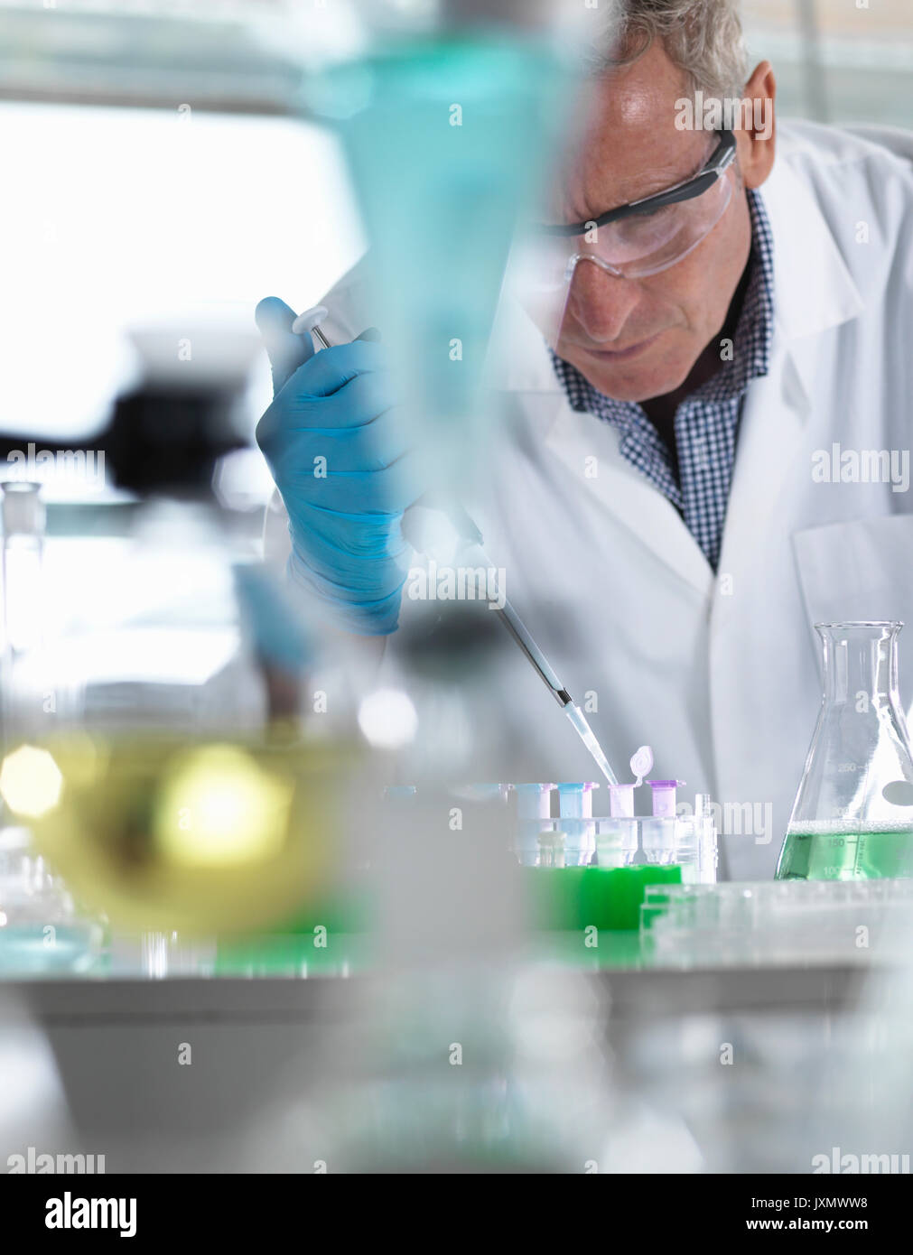 Scientist pipetting samples into eppendorf tubes for testing during an experiment in the laboratory Stock Photo