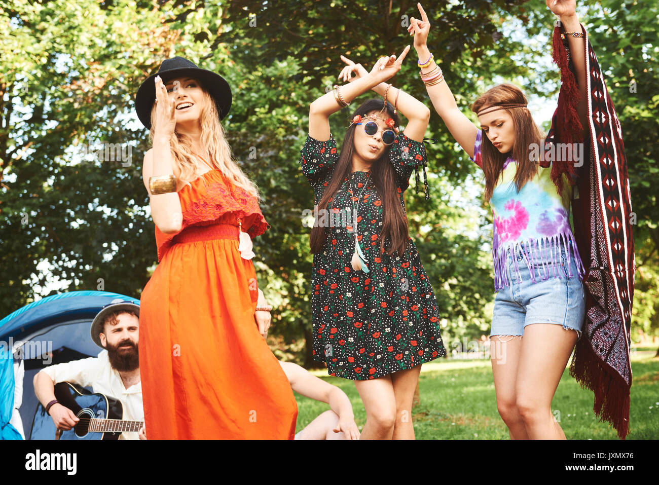 Three young boho women dancing together at festival Stock Photo