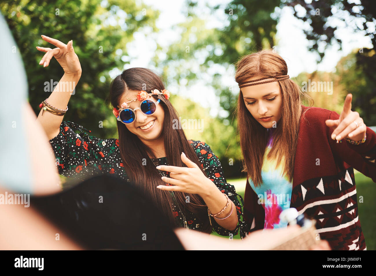 Two young boho women dancing together at festival Stock Photo