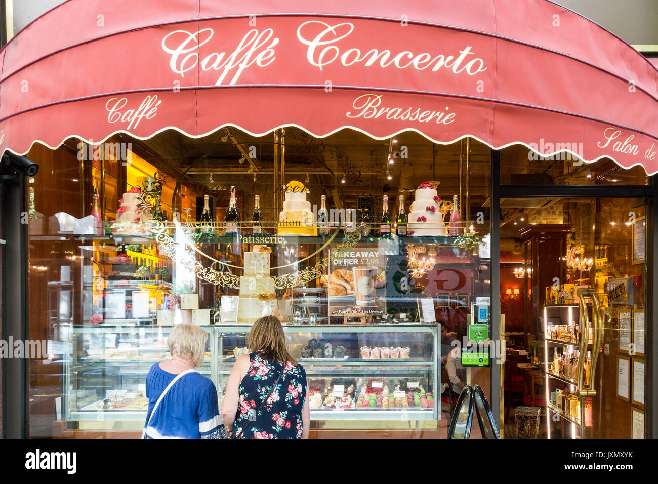 Two women perusing,, looking in the window of the Caffe Concerto, 4-5 Northumberland Ave, Westminster, London WC2N 5BW, UK Stock Photo