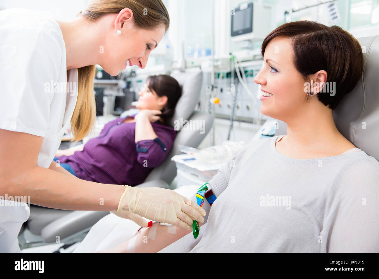 Nurse in drop-in department taking blood from woman donor Stock Photo