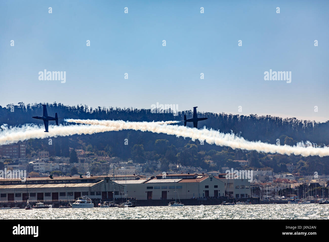 Airshow low flyover cross by 2 planes formation over city during Fleet Week in San Francisco Stock Photo